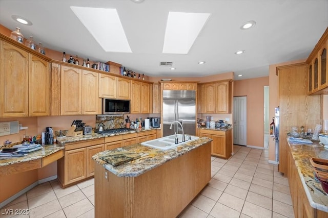 1105 Malachite Ct, Henderson, NV 89011 - kitchen featuring stainless steel appliances, a sink, a kitchen island with sink, light tile patterned floors, and light stone counters