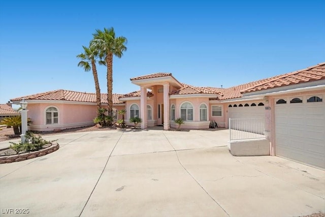 1105 Malachite Ct, Henderson, NV 89011 - mediterranean / spanish house featuring a garage, stucco siding, a tiled roof, and driveway