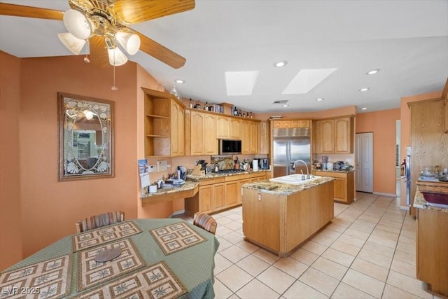 1105 Malachite Ct, Henderson, NV 89011 - kitchen featuring stainless steel appliances, a sink, a skylight, an island with sink, and a ceiling fan