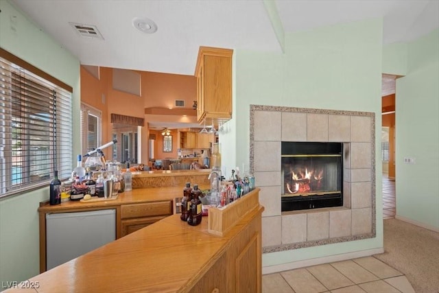 1105 Malachite Ct, Henderson, NV 89011 - bar featuring a tiled fireplace, light tile patterned flooring, light colored carpet, and dishwashing machine