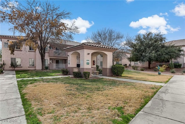 4555 E Sahara Ave Unit 280, Las Vegas, NV 89104 - mediterranean / spanish home featuring a tile roof, stucco siding, and a front yard