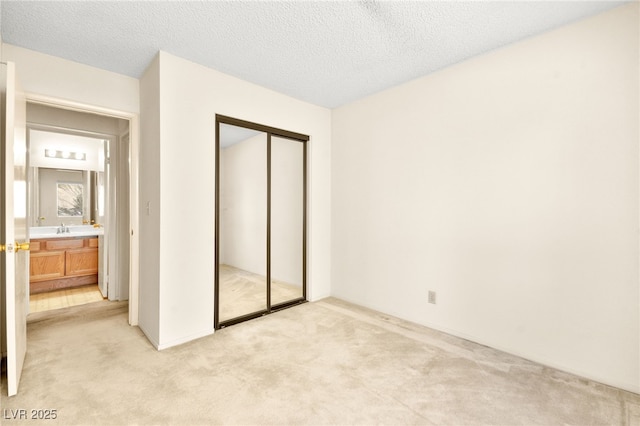 433 Old Palms Dr, Las Vegas, NV 89123 - unfurnished bedroom with light colored carpet, a closet, a sink, and a textured ceiling