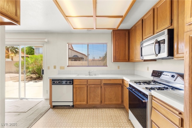 433 Old Palms Dr, Las Vegas, NV 89123 - kitchen featuring white appliances, a sink, light countertops, brown cabinetry, and light flooring