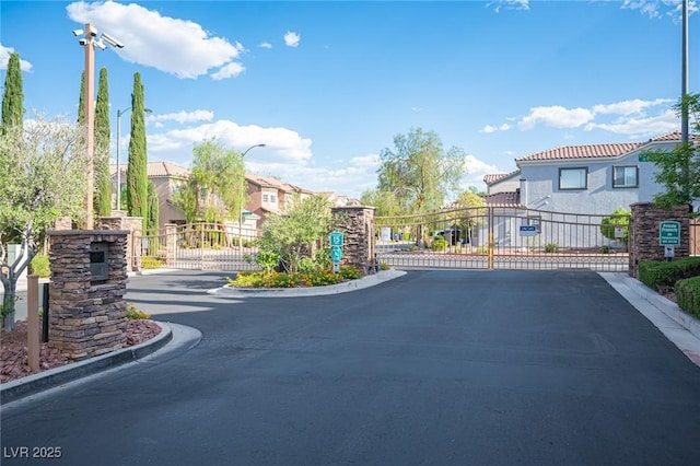 6029 Allanche Ave, Las Vegas, NV 89141 - view of asphalt road featuring a gate, a gated entry, and curbs