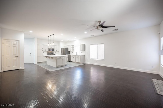 6029 Allanche Ave, Las Vegas, NV 89141 - unfurnished living room with ceiling fan, baseboards, plenty of natural light, wood finished floors, and recessed lighting
