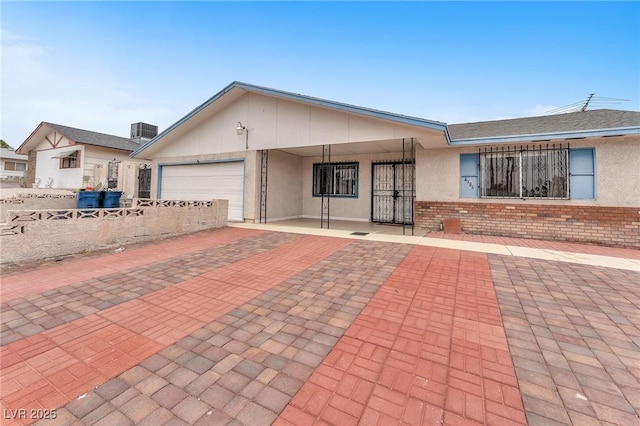 4386 El Cebra Way, Las Vegas, NV 89121 - view of front facade featuring a garage, brick siding, central air condition unit, and stucco siding
