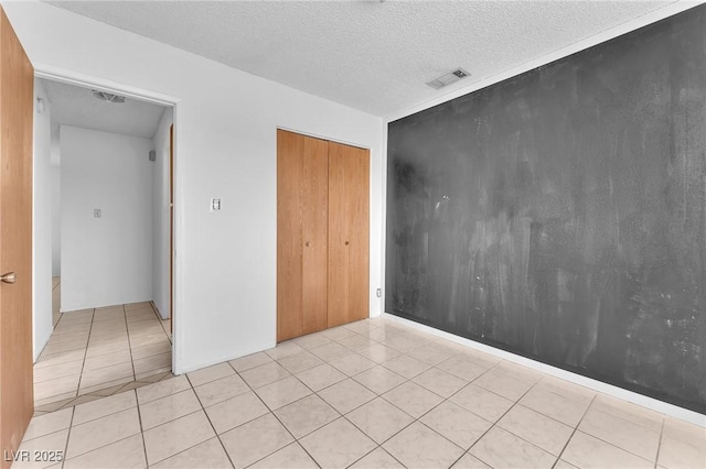 4386 El Cebra Way, Las Vegas, NV 89121 - unfurnished bedroom featuring light tile patterned flooring, a textured ceiling, and a closet