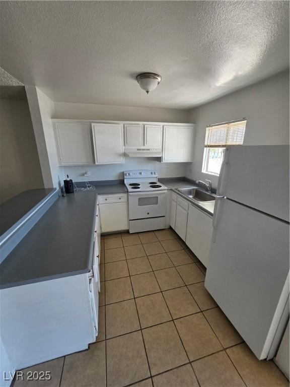 5390 Swenson St Unit 27, Las Vegas, NV 89119 - kitchen featuring white appliances, a sink, under cabinet range hood, white cabinets, and a textured ceiling