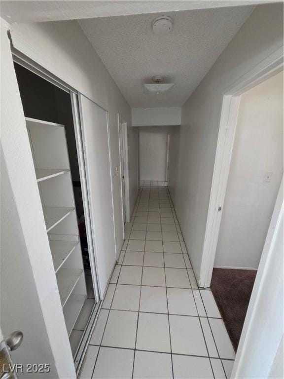 5390 Swenson St Unit 27, Las Vegas, NV 89119 - corridor with light tile patterned flooring and a textured ceiling