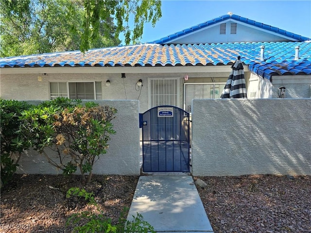 2116 Bavington Dr Unit C, Las Vegas, NV 89108 - doorway to property with a gate, stucco siding, and a tile roof
