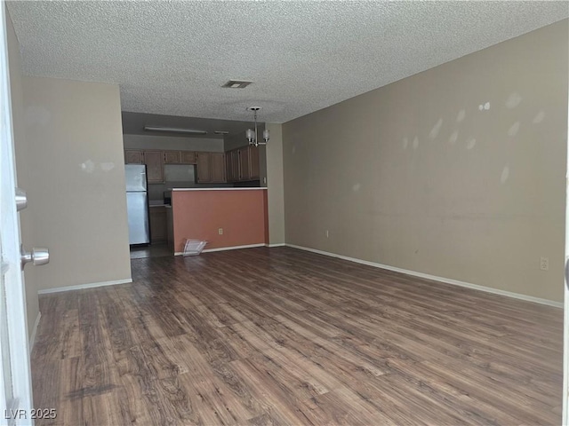 2116 Bavington Dr Unit C, Las Vegas, NV 89108 - unfurnished living room with dark wood-type flooring, a textured ceiling, a chandelier, and baseboards