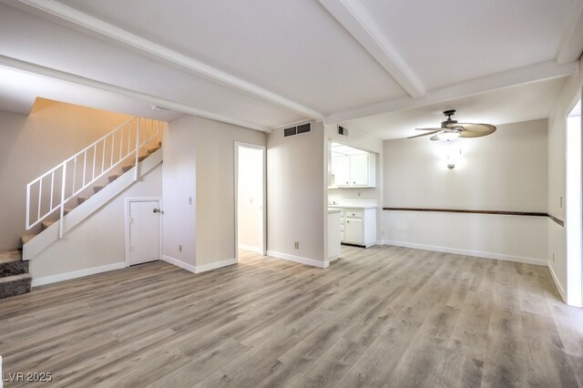 3683 Villa Knolls E Dr, Las Vegas, NV 89120 - unfurnished living room with light wood-type flooring, ceiling fan, stairway, beamed ceiling, and baseboards
