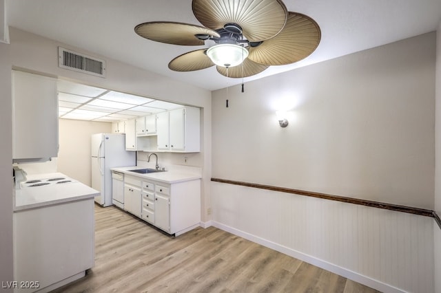 3683 Villa Knolls E Dr, Las Vegas, NV 89120 - kitchen featuring white appliances, a sink, light countertops, a ceiling fan, and light wood-type flooring