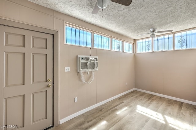 3683 Villa Knolls E Dr, Las Vegas, NV 89120 - unfurnished room featuring ceiling fan, a wall unit AC, wood finished floors, a textured ceiling, and baseboards