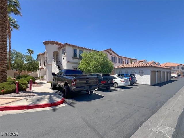 50 Aura De Blanco St Unit 18204, Henderson, NV 89074 - mediterranean / spanish-style home with stucco siding, a tiled roof, a residential view, and uncovered parking