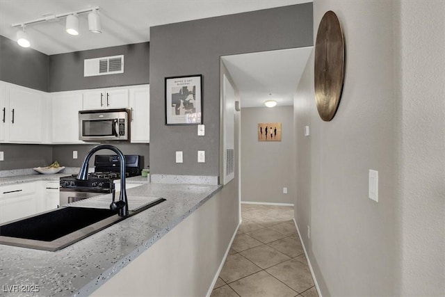 50 Aura De Blanco St Unit 18204, Henderson, NV 89074 - kitchen with appliances with stainless steel finishes, light tile patterned flooring, white cabinets, light stone countertops, and baseboards