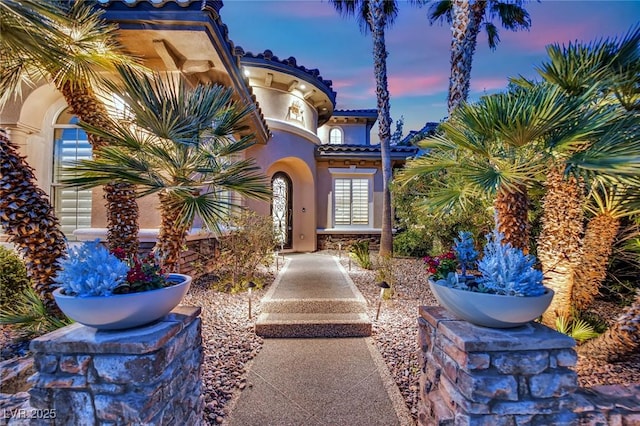 1972 Alcova Ridge Dr, Las Vegas, NV 89135 - exterior entry at dusk featuring stucco siding and a tile roof