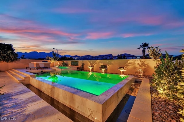 1972 Alcova Ridge Dr, Las Vegas, NV 89135 - pool at dusk featuring an in-ground hot tub, a fenced backyard, and a mountain view