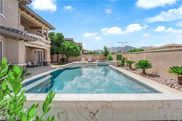 1972 Alcova Ridge Dr, Las Vegas, NV 89135 - view of swimming pool featuring a fenced backyard, a mountain view, a patio, and a pool with connected hot tub