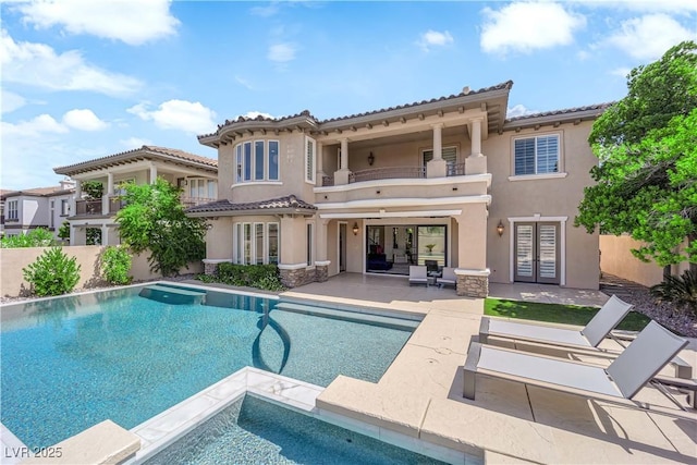 1972 Alcova Ridge Dr, Las Vegas, NV 89135 - rear view of house with a balcony, french doors, a patio area, stucco siding, and a tiled roof