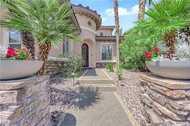 1972 Alcova Ridge Dr, Las Vegas, NV 89135 - view of exterior entry with stucco siding, stone siding, and a tiled roof