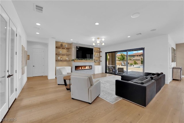 1972 Alcova Ridge Dr, Las Vegas, NV 89135 - living room with a glass covered fireplace, light wood-style floors, and recessed lighting