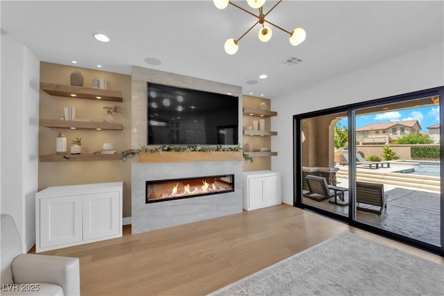 1972 Alcova Ridge Dr, Las Vegas, NV 89135 - living area with wood finished floors, a chandelier, a glass covered fireplace, and recessed lighting