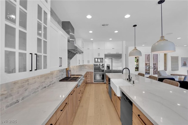 1972 Alcova Ridge Dr, Las Vegas, NV 89135 - kitchen with a sink, built in appliances, light wood-style floors, glass insert cabinets, and wall chimney exhaust hood