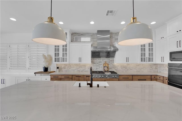 1972 Alcova Ridge Dr, Las Vegas, NV 89135 - kitchen featuring wall chimney exhaust hood, a sink, tasteful backsplash, glass insert cabinets, and recessed lighting