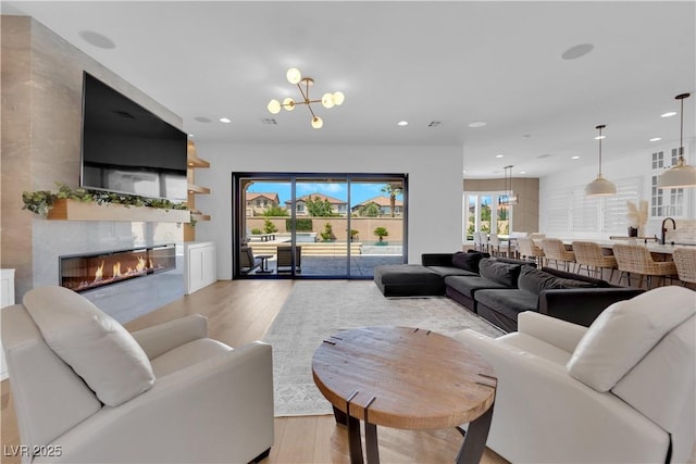 1972 Alcova Ridge Dr, Las Vegas, NV 89135 - living area with wood finished floors, a glass covered fireplace, recessed lighting, and a chandelier