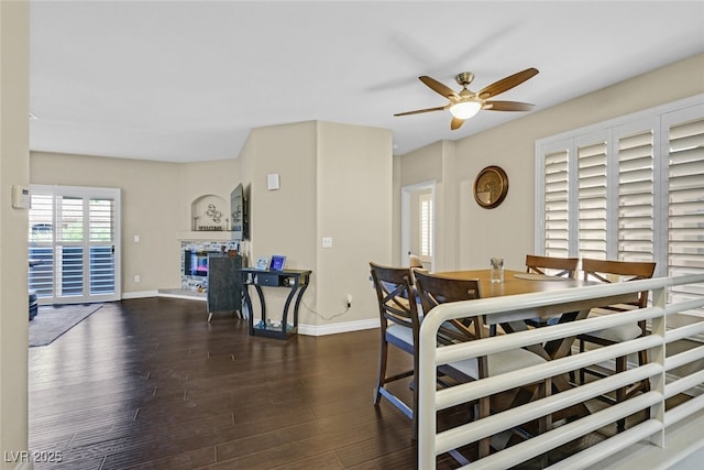 2050 W Warm Springs Rd Unit 823, Henderson, NV 89014 - dining room with a ceiling fan, wood finished floors, a glass covered fireplace, and baseboards