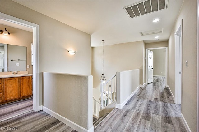 7083 Somera Way, Las Vegas, NV 89113 - corridor with an upstairs landing, light wood-style flooring, and baseboards