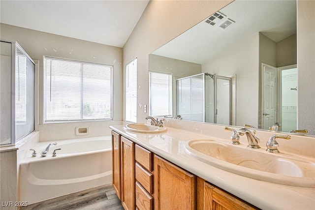 7083 Somera Way, Las Vegas, NV 89113 - bathroom with a garden tub, wood finished floors, double vanity, a shower stall, and lofted ceiling