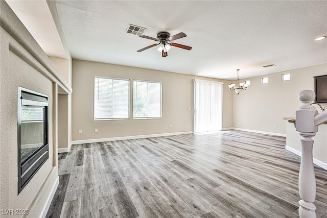 7083 Somera Way, Las Vegas, NV 89113 - unfurnished living room featuring a chandelier, wood finished floors, ceiling fan, and baseboards
