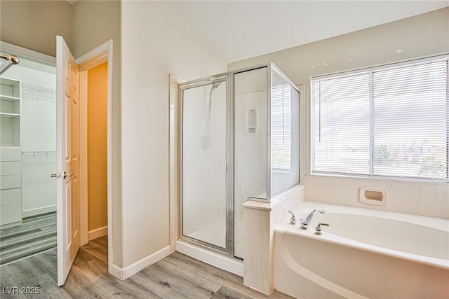 7083 Somera Way, Las Vegas, NV 89113 - full bathroom featuring a stall shower, a bath, wood finished floors, a walk in closet, and vaulted ceiling