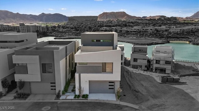 40 Heron Harbour Dr, Henderson, NV 89011 - view of front of house with a garage, stucco siding, a water and mountain view, and driveway