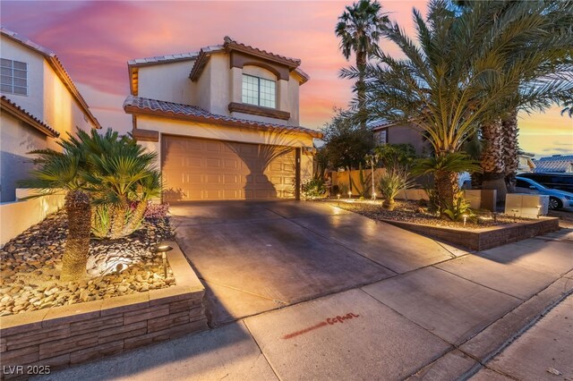 5779 Baffy Cir, Las Vegas, NV 89142 - mediterranean / spanish house featuring concrete driveway, stucco siding, a tiled roof, and an attached garage