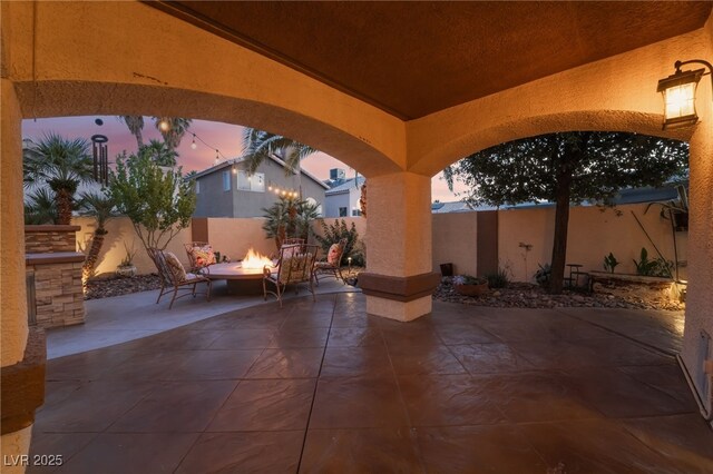 5779 Baffy Cir, Las Vegas, NV 89142 - patio terrace at dusk featuring a patio, a fire pit, and a fenced backyard