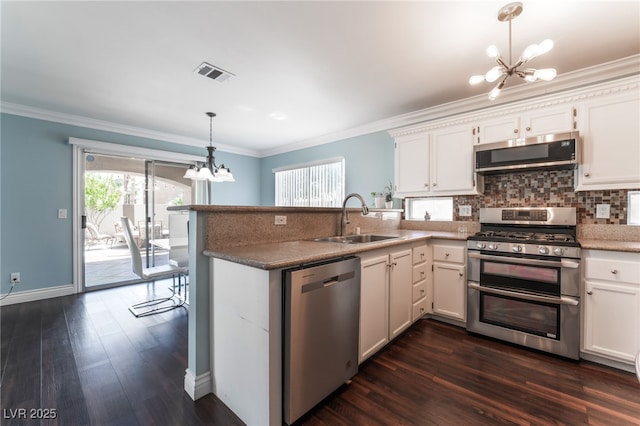5779 Baffy Cir, Las Vegas, NV 89142 - kitchen with appliances with stainless steel finishes, a chandelier, a sink, dark wood-style flooring, and a peninsula