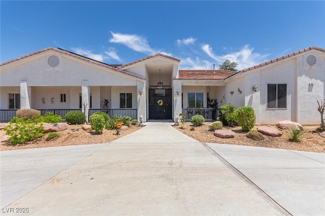 60 N Fogg St, Las Vegas, NV 89110 - view of front of home featuring stucco siding, covered porch, and a tiled roof