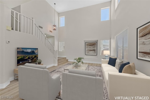 4132 Joyous St, North Las Vegas, NV 89032 - living area featuring stairs, a towering ceiling, wood finished floors, and baseboards