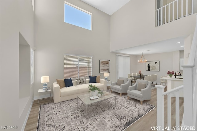 4132 Joyous St, North Las Vegas, NV 89032 - living area with a towering ceiling, light wood-type flooring, baseboards, and a chandelier