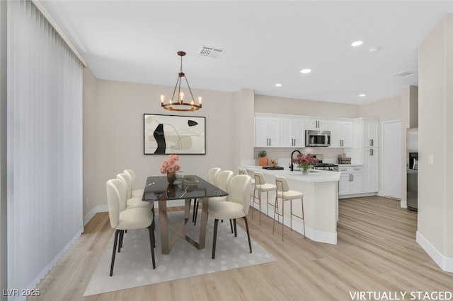 4132 Joyous St, North Las Vegas, NV 89032 - dining room with light wood-style floors, a chandelier, baseboards, and recessed lighting