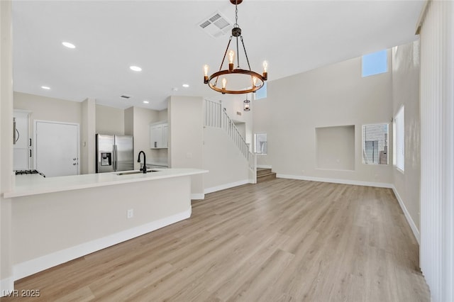4132 Joyous St, North Las Vegas, NV 89032 - unfurnished living room featuring a sink, light wood-type flooring, a chandelier, baseboards, and recessed lighting