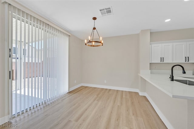 4132 Joyous St, North Las Vegas, NV 89032 - unfurnished dining area with a sink, light wood-style flooring, a chandelier, baseboards, and recessed lighting