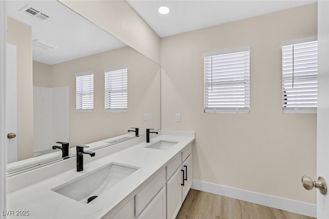 4132 Joyous St, North Las Vegas, NV 89032 - bathroom featuring double vanity, wood finished floors, baseboards, and a shower