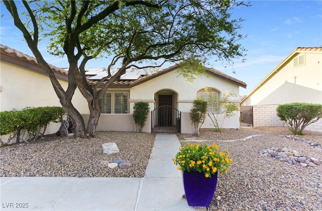 8928 Rusty Rifle Ave, Las Vegas, NV 89143 - view of front of home with a gate, roof mounted solar panels, stucco siding, and a tiled roof