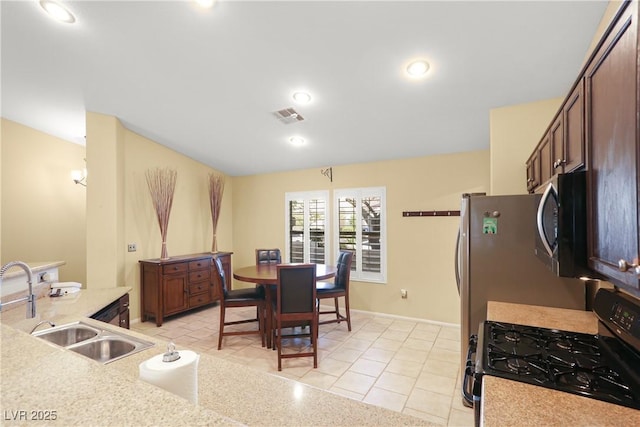 8928 Rusty Rifle Ave, Las Vegas, NV 89143 - kitchen featuring gas range, black microwave, light countertops, light tile patterned flooring, and recessed lighting