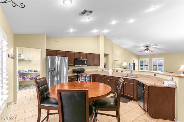 8928 Rusty Rifle Ave, Las Vegas, NV 89143 - kitchen with appliances with stainless steel finishes, a peninsula, vaulted ceiling, light tile patterned floors, and a ceiling fan