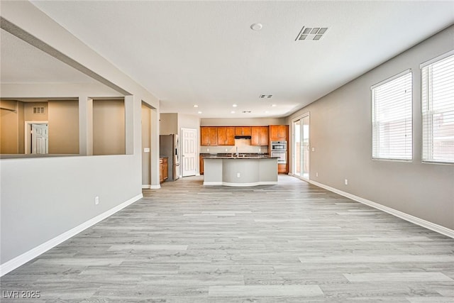 9271 Martel Ave, Las Vegas, NV 89148 - unfurnished living room with baseboards, healthy amount of natural light, light wood-style flooring, recessed lighting, and a sink